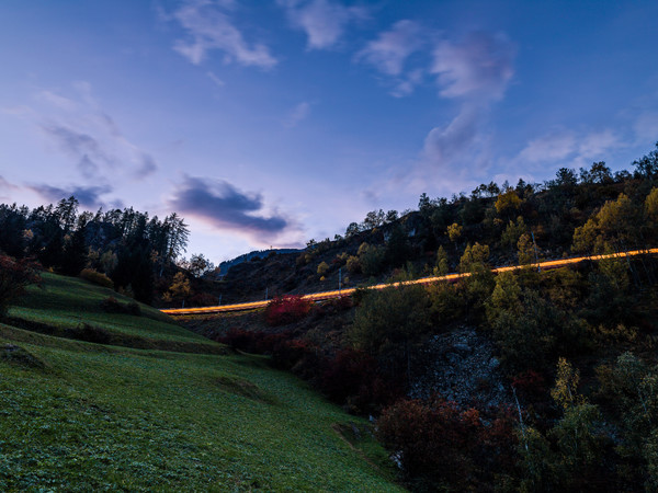 Abendstimmung mit Leuchtspuren der Rhätischen Bahn bei Ardez im Unterengadin.