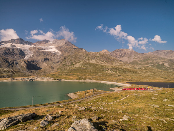 Ein Triebzug der Rhätischen Bahn unterwegs in der hochalpinen Landschaft auf dem Berninapass.
