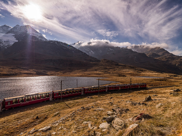 Bernina Express der Rhätischen Bahn unterwegs zwischen Lago Bianco und Lej Nair auf dem Berninapass. Im Hintergrund der Munt Pers.