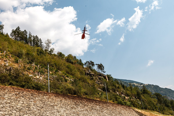 Betonierarbeiten mit Hilfe eines Helikopter oberhalb der Strasse zwischen Brusio und Miralago.
