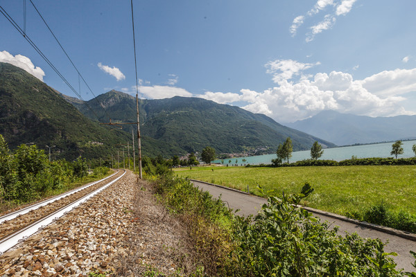 Die Zuglinie Lecce?Chiavenna am Ufer des Lago di Mezzola, markant die weiss angemalten Gleise (Hitzeschutz)