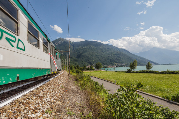 Die Zuglinie Lecce?Chiavenna am Ufer des Lago di Mezzola, markant die weiss angemalten Gleise (Hitzeschutz)