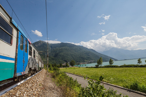 Die Zuglinie Lecce?Chiavenna am Ufer des Lago di Mezzola, markant die weiss angemalten Gleise (Hitzeschutz)