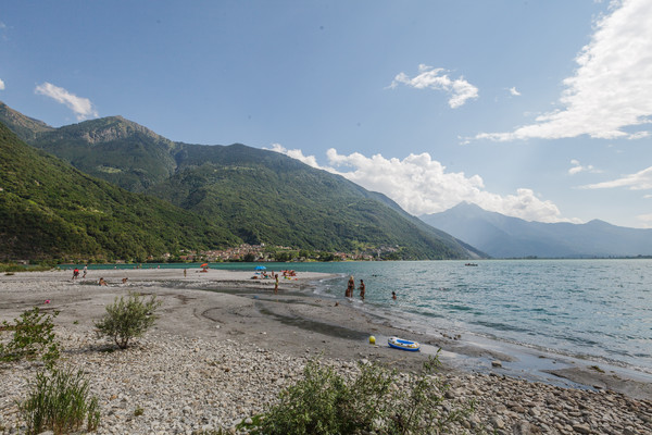 Badende am Ufer des Lago di Mezzola zwischen Chiavenna und Còlico, am linken Bildrand das Dorf San Fedele und Verceia