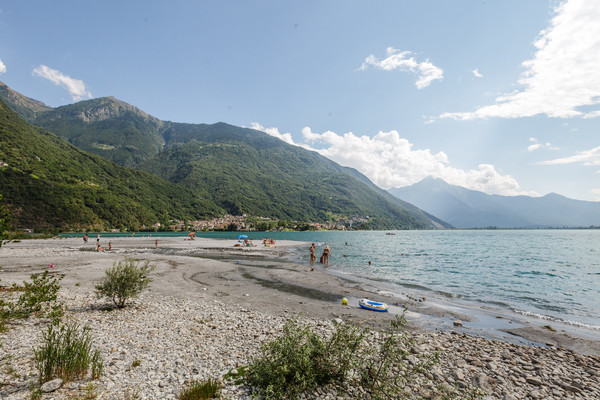 Badende am Ufer des Lago di Mezzola zwischen Chiavenna und Còlico, am linken Bildrand das Dorf San Fedele und Verceia