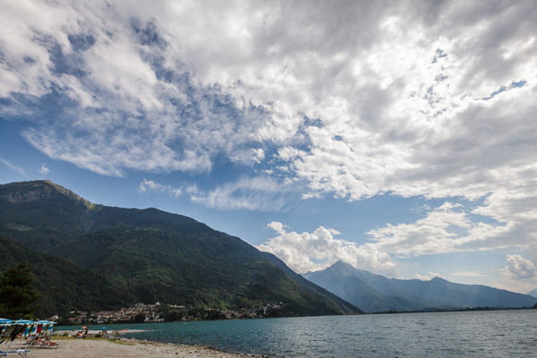 Badende am Ufer des Lago di Mezzola zwischen Chiavenna und Còlico, am linken Bildrand das Dorf San Fedele und Verceia