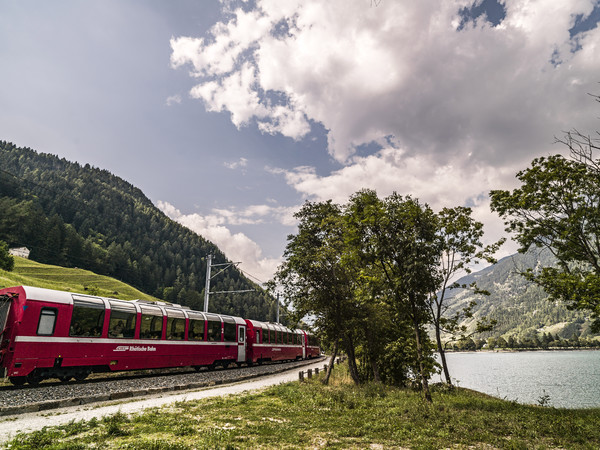Unterwegs im Bernina Express der Rhätischen Bahn am Ufer des Lago di Poschiavo im Puschlav.