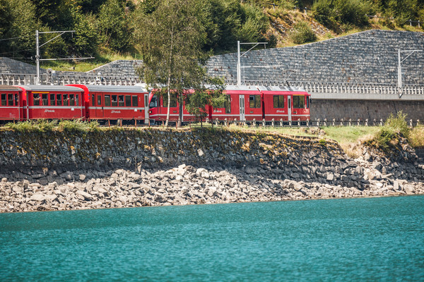 Die Rhätische Bahn am Ufer des Lago di Poschiavo bei Miralago im Puschlav.