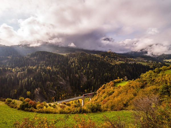 Herbstliche Aussicht von der Strasse nach Ftan auf das Val Corgnanca-Viadukt der Rhätischen Bahn, im Hintergrund das Wahrzeichen des Unterengadins, da