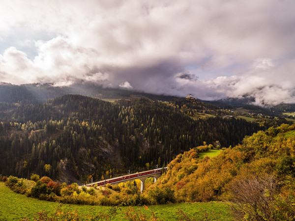 Herbstliche Aussicht von der Strasse nach Ftan auf das Val Corgnanca-Viadukt der Rhätischen Bahn, im Hintergrund das Wahrzeichen des Unterengadins, da