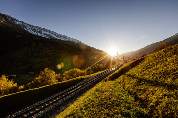 Goldene Abendstimmung entlang den Gleisen der Rhätischen Bahn bei Sumvitg im Bündner Oberland, Graubünden, Schweiz.