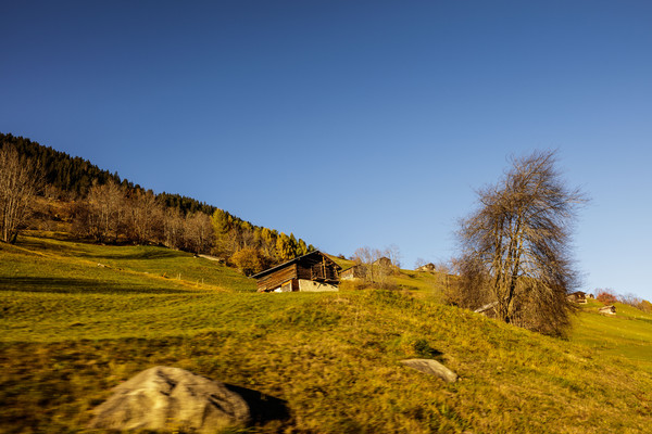 Goldene Abendstimmung und alte Ställe/Heuschober bei Sumvitg im Bündner Oberland, Graubünden, Schweiz.
