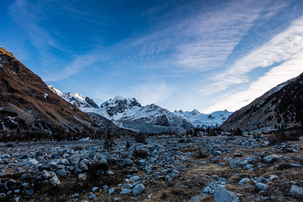 Abendliches Bergpanorama mit Eisblasen und gefrorene Bäche im Val Roseg bei Pontresina im Oberengadin.