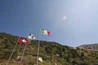 Foto: Die drei Fahnen auf dem Stausee im Valle di Lei